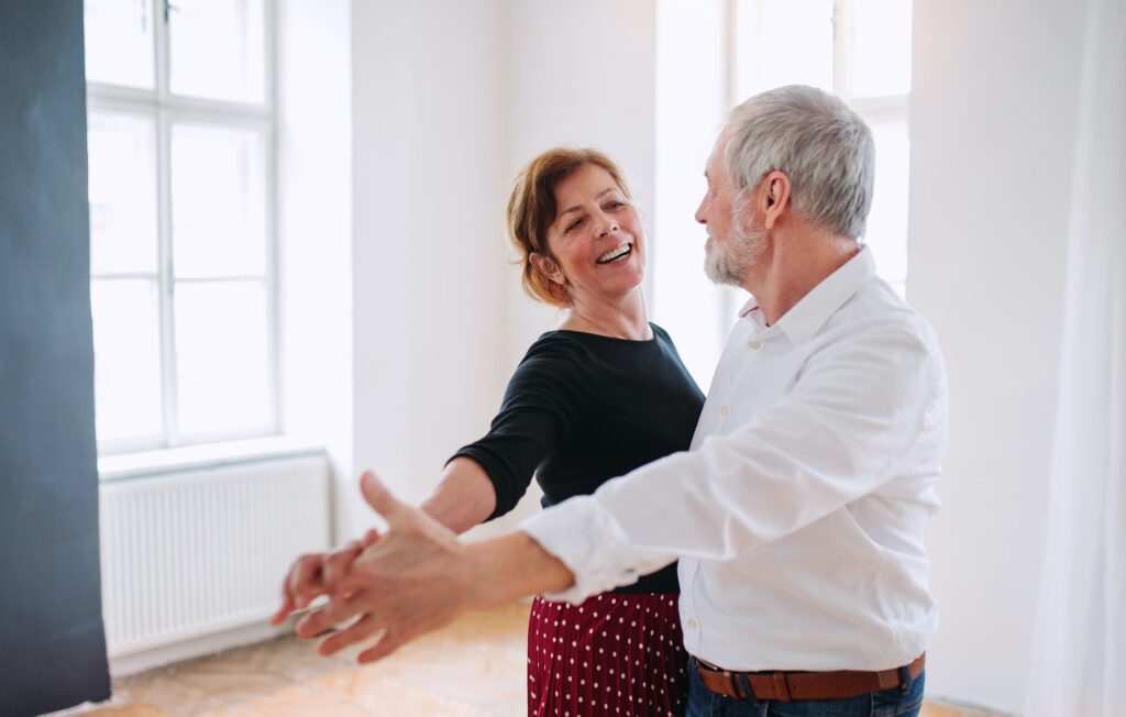 Senior couple attending dancing class in community center